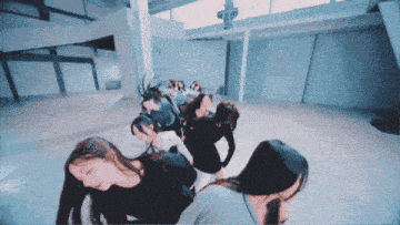 a group of women are standing in a circle in a room