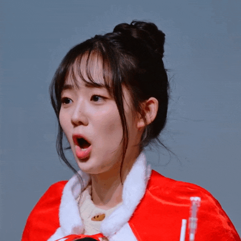 a woman wearing a red cape with the letter l on it makes a surprised face