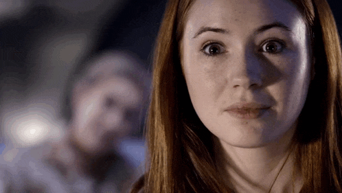 a woman with red hair is looking at the camera