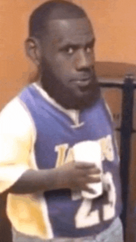 a man in a lakers jersey is holding a cup of coffee