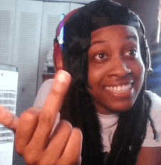 a woman wearing headphones and a baseball cap giving the middle finger