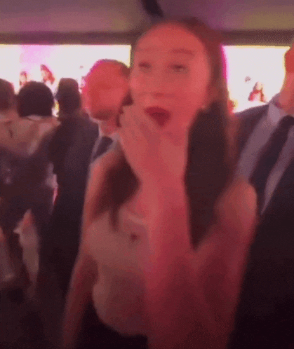 a blurry photo of a woman covering her mouth with her hand