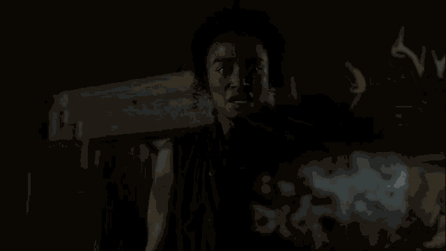 a man and a woman are standing in a dark room with a deer head on the wall