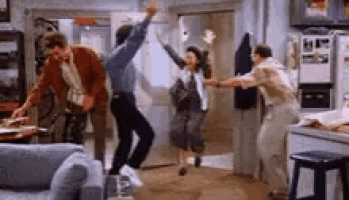 a group of people are dancing in a living room in front of a refrigerator .