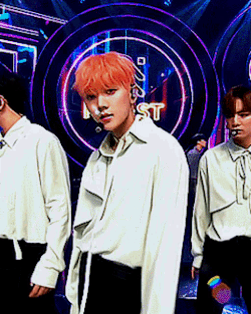 a man with orange hair is standing in front of a neon sign that says best