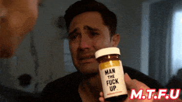 a man is holding a bottle that says man the fuck up