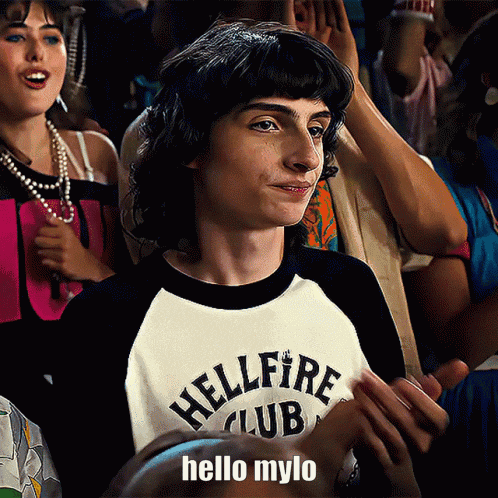 a boy wearing a hellfire club shirt is clapping