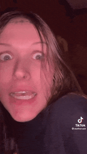 a girl with a tattoo on her forehead is making a funny face on tiktok