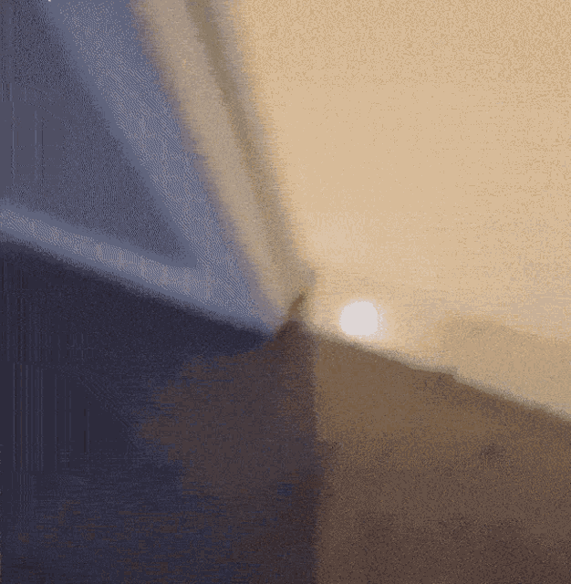 a corner of a room with a light shining on the floor