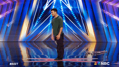 a man is standing on a stage with a nbc logo in the corner