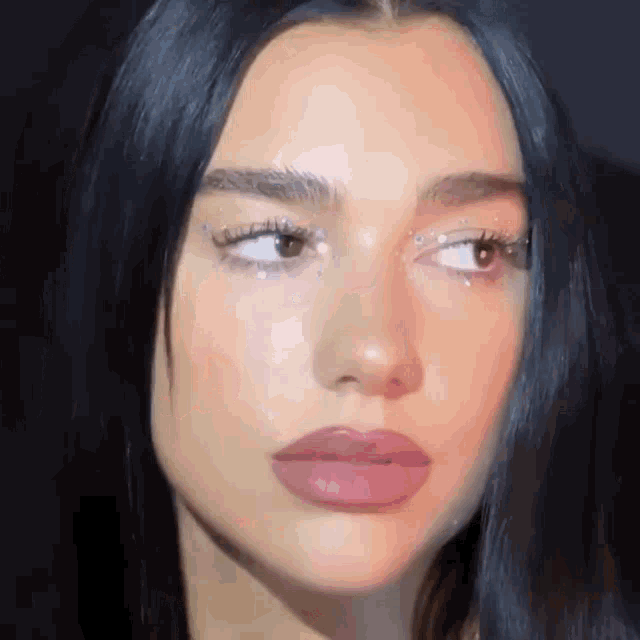 a close up of a woman 's face with a black background .