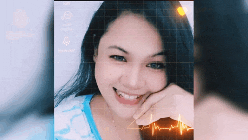 a woman in a blue shirt is smiling and looking at the camera