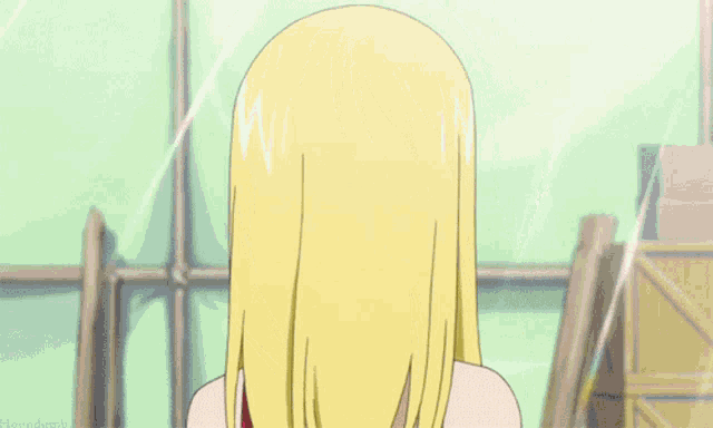 a girl with blonde hair and a red top smiles for the camera