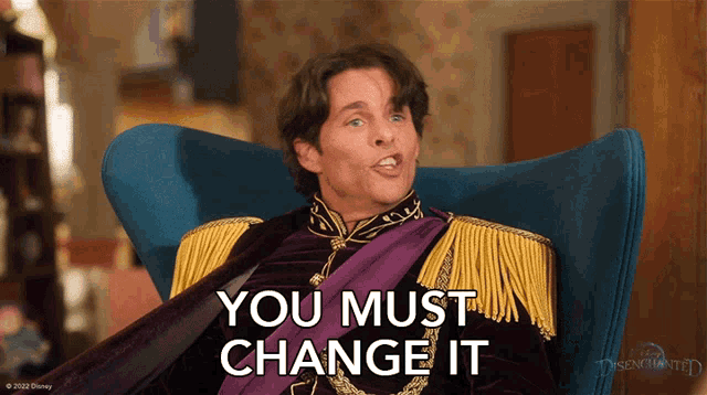 a man sitting in a chair with the words you must change it