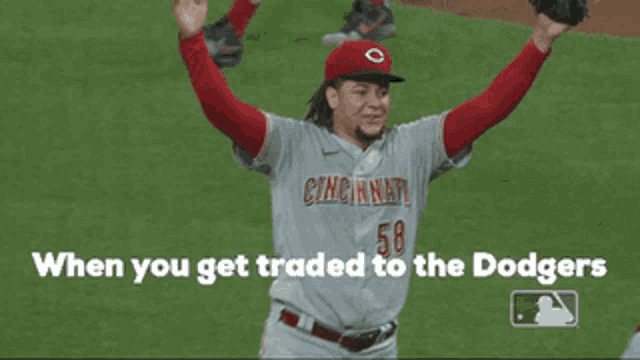 a cincinnati baseball player is holding his arms in the air
