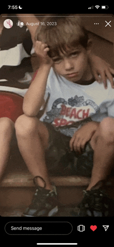 a young boy wearing a shirt that says beach on it