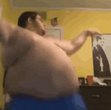a man is dancing in front of a picture of a man in a suit and tie