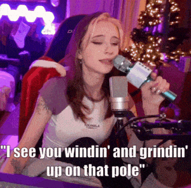 a girl singing into a microphone with the words " i see you windin ' and grindin ' up on that pole " below her