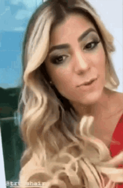the woman is wearing a red dress and has long blonde hair