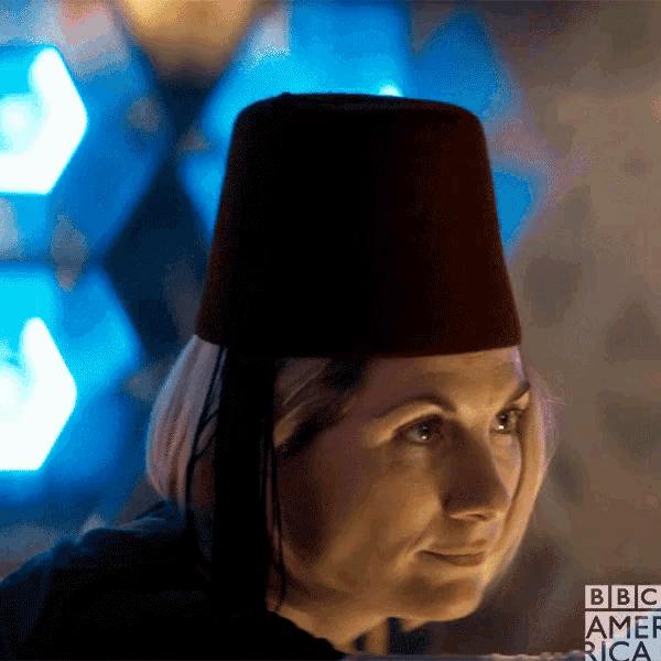 a woman wearing a black hat with bbc america written on the bottom right