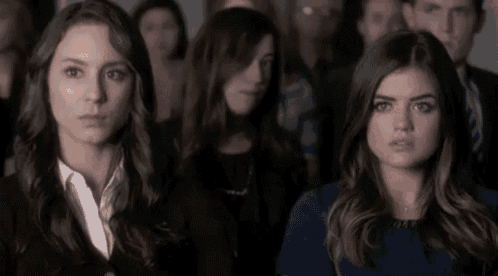 two women are sitting in front of a crowd of people .