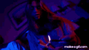 a man is lighting a cigarette in a dark room .