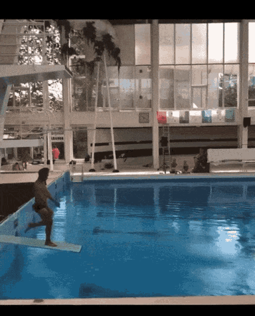 a man is jumping into a swimming pool with a sign that says ' l' eau ' on it