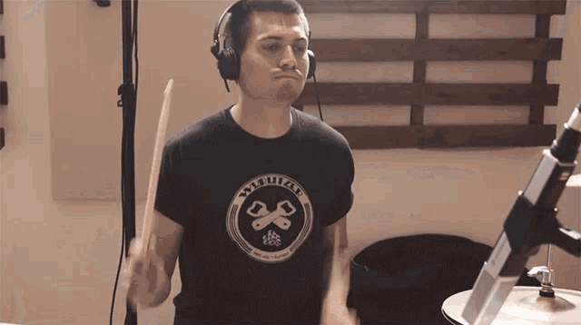 a man wearing headphones is playing drums and has a shirt on that says modular