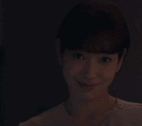 a woman is smiling while holding a knife with a purple light on it