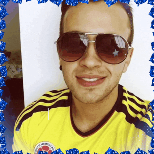 a man wearing sunglasses and a yellow colombia shirt