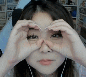 a woman making a heart shape with her hands