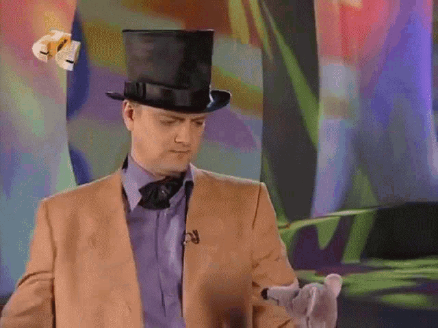 a man wearing a top hat and a suit is holding something
