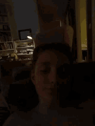 a person in a dark room with a picture on the wall that says ' jesus '