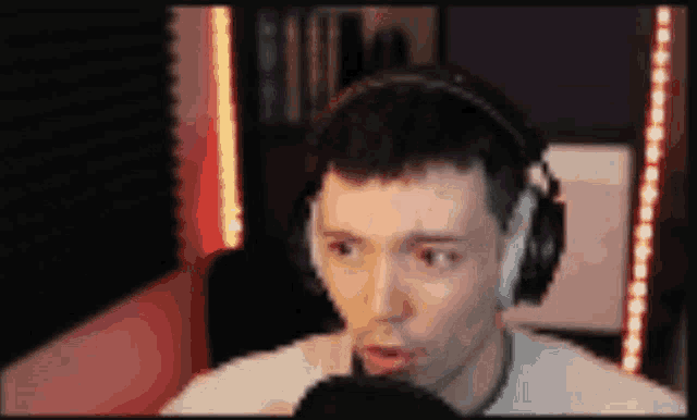 a man wearing headphones is talking into a microphone ..