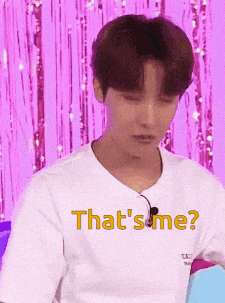 a young man wearing a white t-shirt with the words `` that 's me '' written on it is looking down .