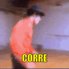 a man in a red shirt and hat is standing in front of a wall with the word corre written on it .