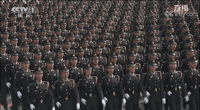 a large group of soldiers marching in a line with cctv 1 in the background