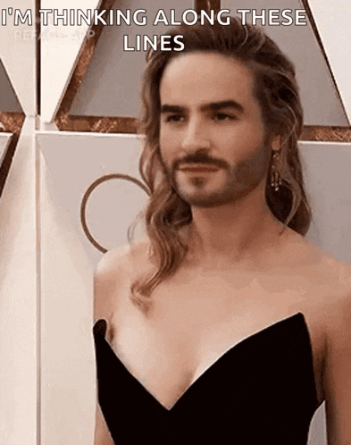 a man with long hair and a beard is wearing a black dress and talking .