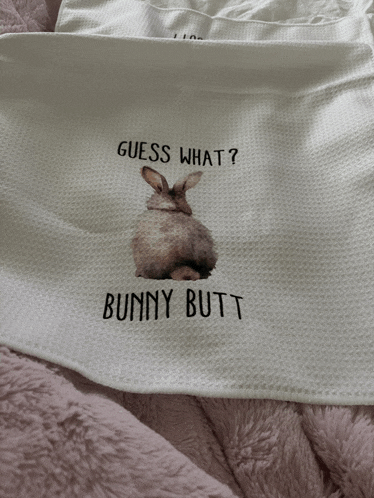 a white cloth with a picture of a bunny and the words " guess what bunny butt "