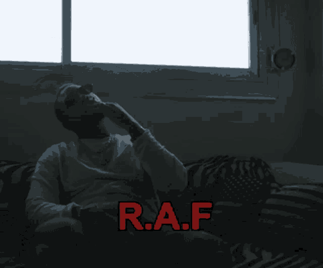 a man sitting on a couch with the word raf in red letters