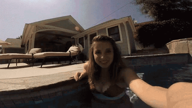 a woman in a bikini is swimming in a pool