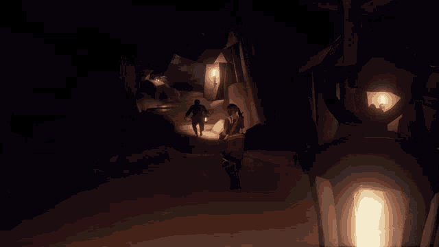 a group of people walking through a dark cave with a lantern