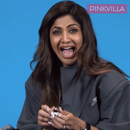 a woman is making a funny face in front of a blue background with pinkvilla written on it