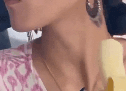 a close up of a woman 's neck and neckline with a tattoo on her neck .