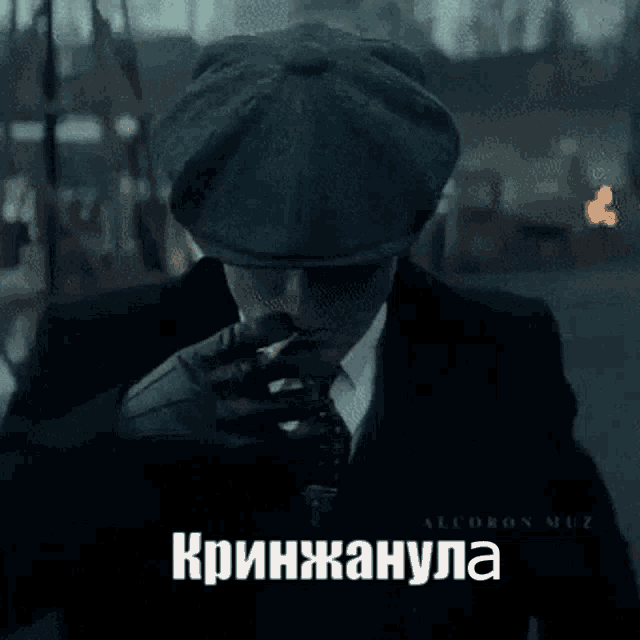 a man in a suit and tie is smoking a cigarette and looking at his phone .