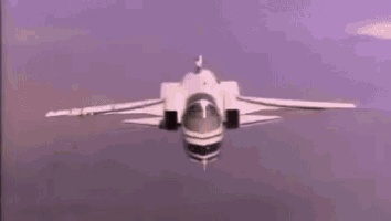 a fighter jet is flying through a cloudy sky with its wings spread .