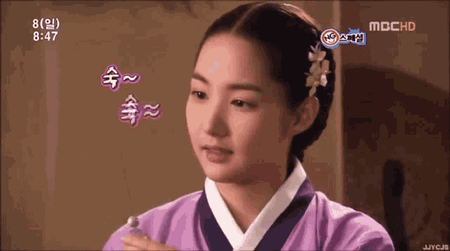 a woman in a purple dress with a flower in her hair is on a screen that says mcchd