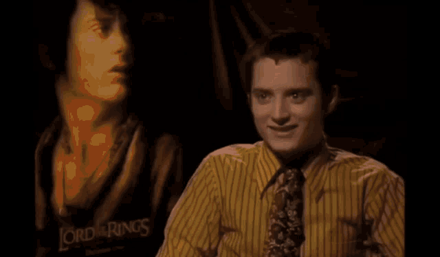 a close up of a man 's face with a yellow shirt on in a dark room .