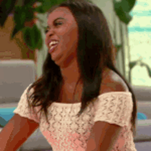 a woman is sitting on a couch and laughing .