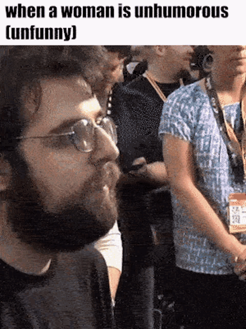 a man with glasses and a beard is standing in a crowd with the caption when a woman is unhumourous
